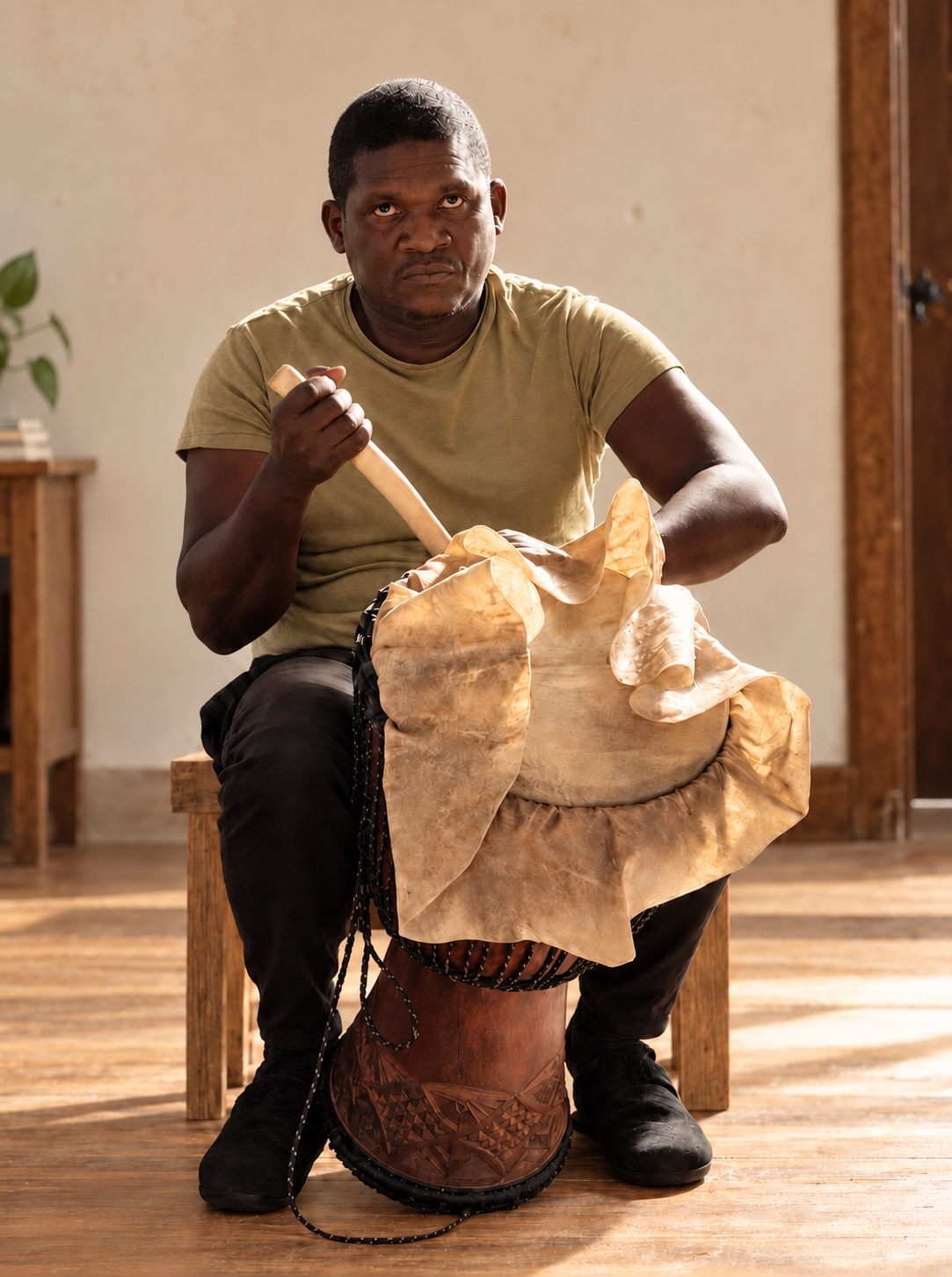 Instrumente Trommelbauer zieht ein Naturfell auf eine Djembe