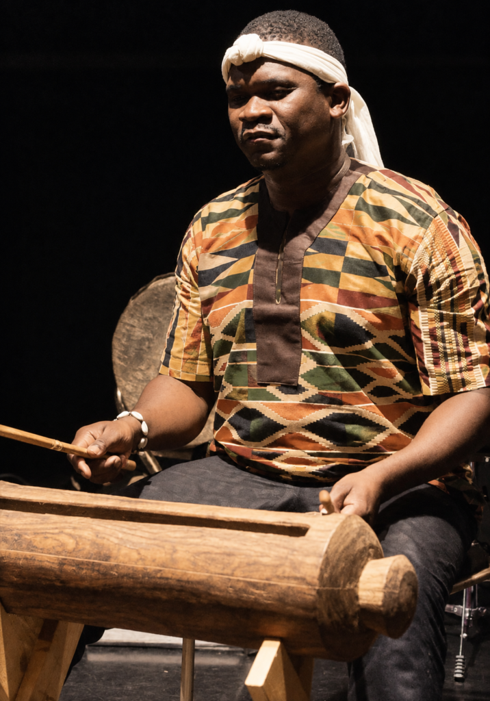 Billy Konaté mit einem traditionellen Schlaginstrument aus Guinea