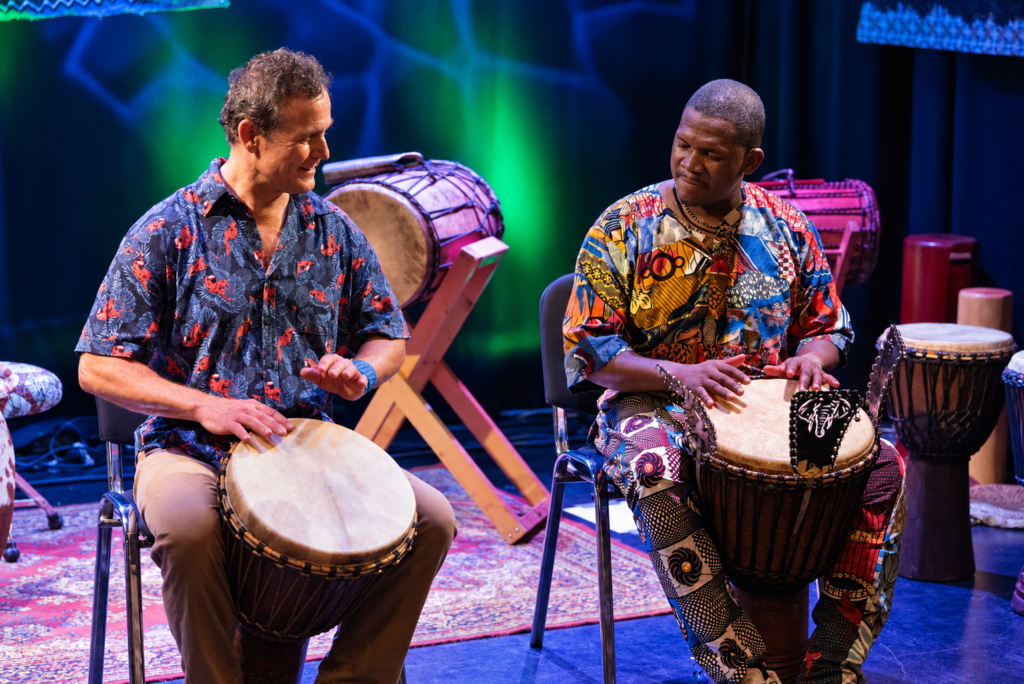 Gerhard Kero von der Beat Factory und Billy Konaté spielen gemeinsam Djembé auf der Bühne in Graz.