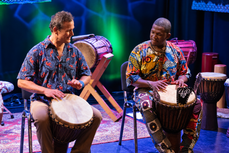 Gerhard Kero von der Beat Factory und Billy Konaté spielen gemeinsam Djembé auf der Bühne in Graz.