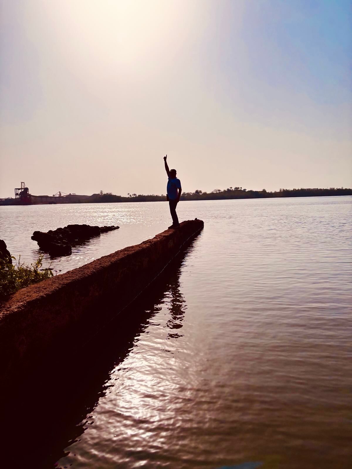 Eine Person auf einem schmalen Steg am Wasser in Boffa